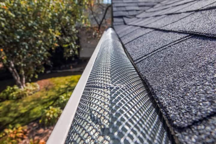 A contractor demonstrating the effectiveness of a gutter guard to a potential client in Savannah